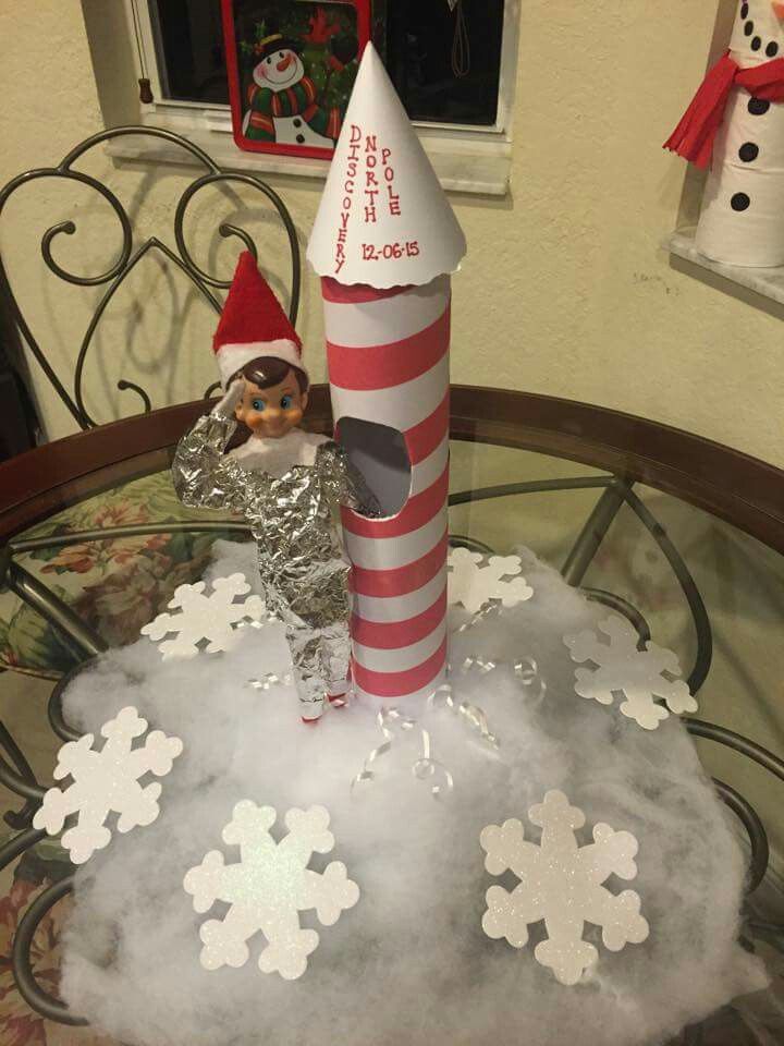 an elf is sitting on top of a table with snowflakes and a candy cane