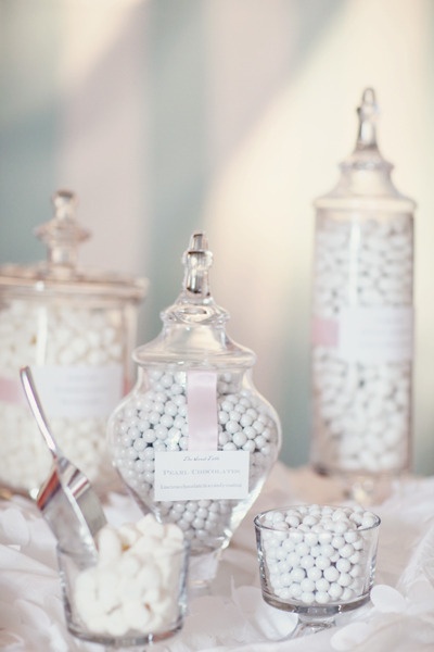 several glass jars filled with white candy on top of a table