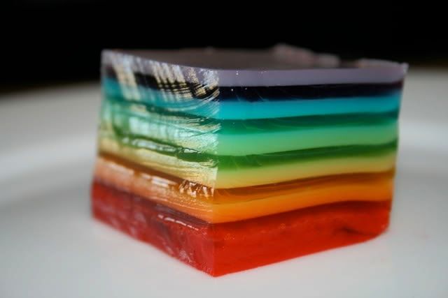 a multicolored cake sitting on top of a white plate