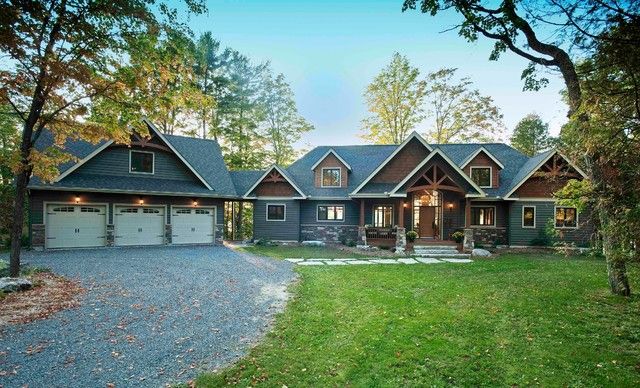 a large house with lots of windows in the front and side of it, surrounded by trees