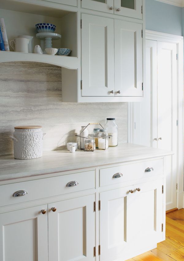 a kitchen with white cabinets and wooden floors