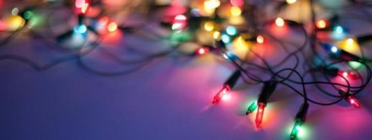 multicolored christmas lights are arranged on a purple background with room for text or image