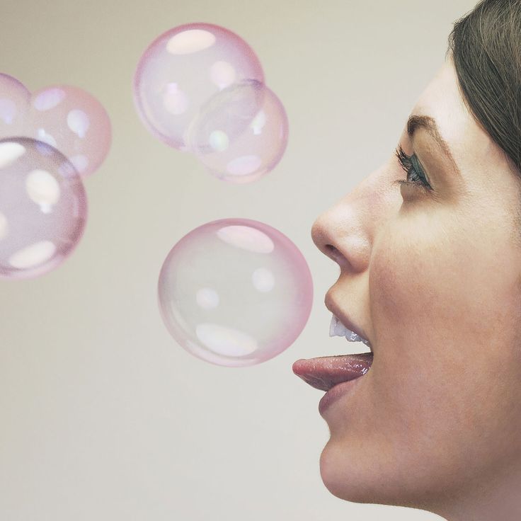 a woman blowing bubbles with her mouth