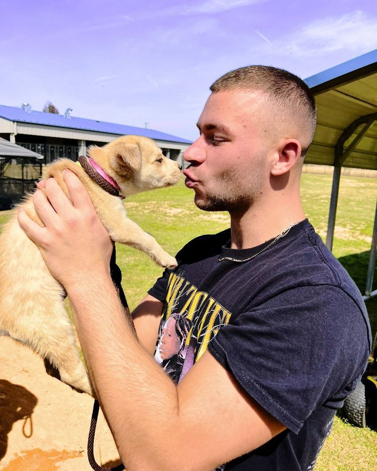 a man holding a small dog in his arms