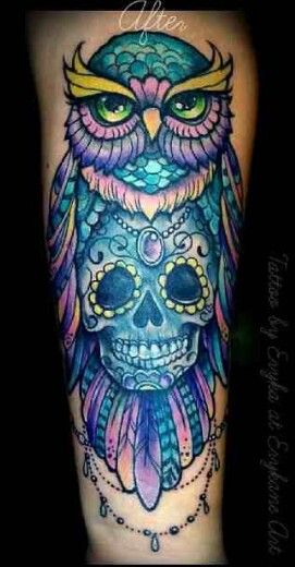 an owl tattoo on the leg with a skull and feathers around its neck, which is decorated