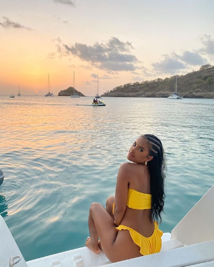 a woman sitting on top of a boat in the ocean