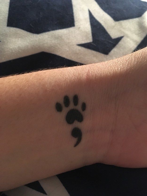 a person with a small paw tattoo on their wrist