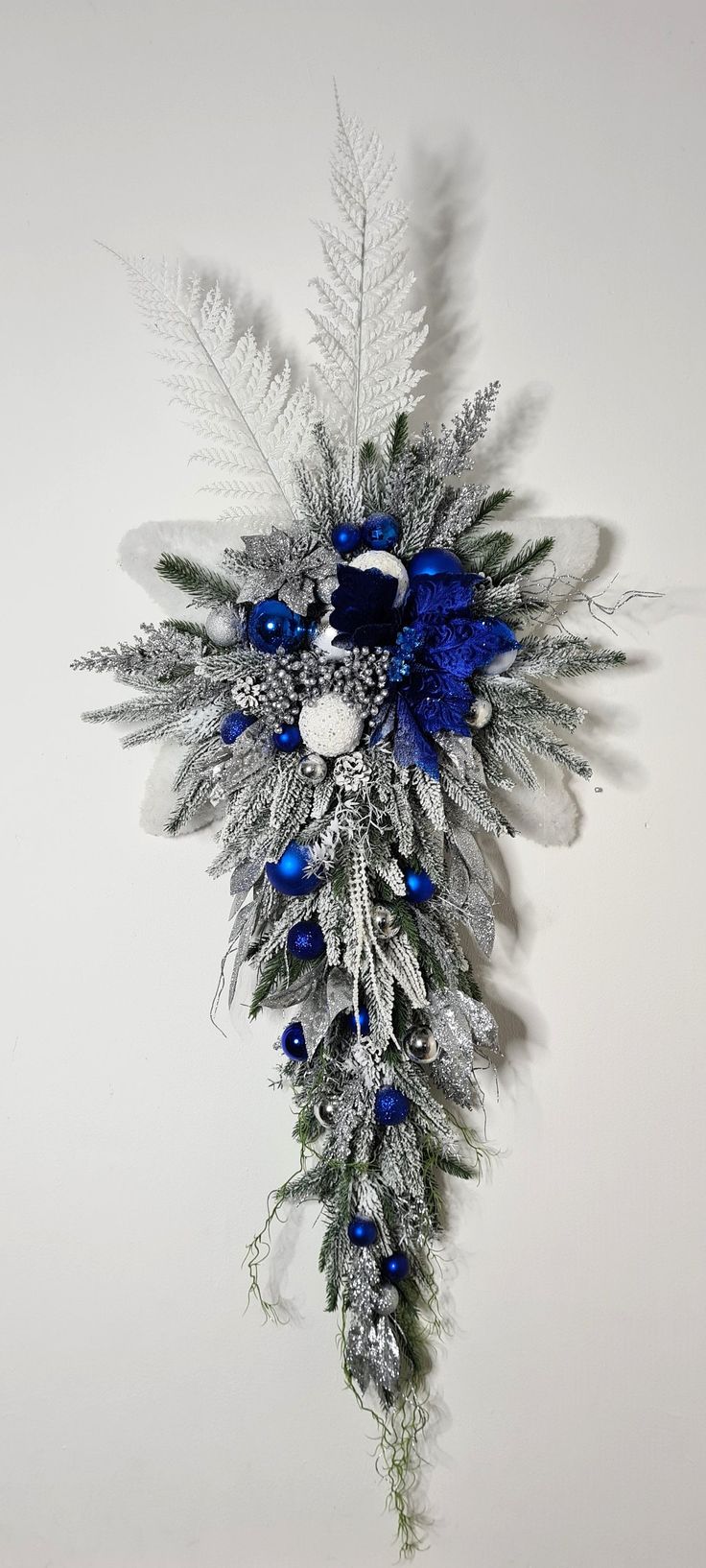 a blue and silver christmas decoration hanging on the wall