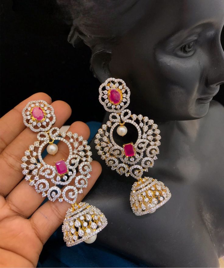 Elevate your look with these striking Royal Look Large CZ Jhumka Drop Earrings. Handcrafted from brass, this chic jhumka style is adorned with cubic zirconia stones for a glamorous effect. Perfect for special occasions, these earrings are sure to make you shine. Intricate Design Jhumkas For Reception, Stone Work Jhumkas For Reception, Stone Work Drop Jhumkas For Reception, Wedding Jhumkas With Intricate Cubic Zirconia Design, Wedding Cubic Zirconia Jhumkas With Intricate Design, Elegant American Diamond Danglers With Latkans, Heavy Jhumkas For Reception, Diamond Jhumkas With Intricate Design In Bollywood Style, Heavy Drop Jhumkas For Reception