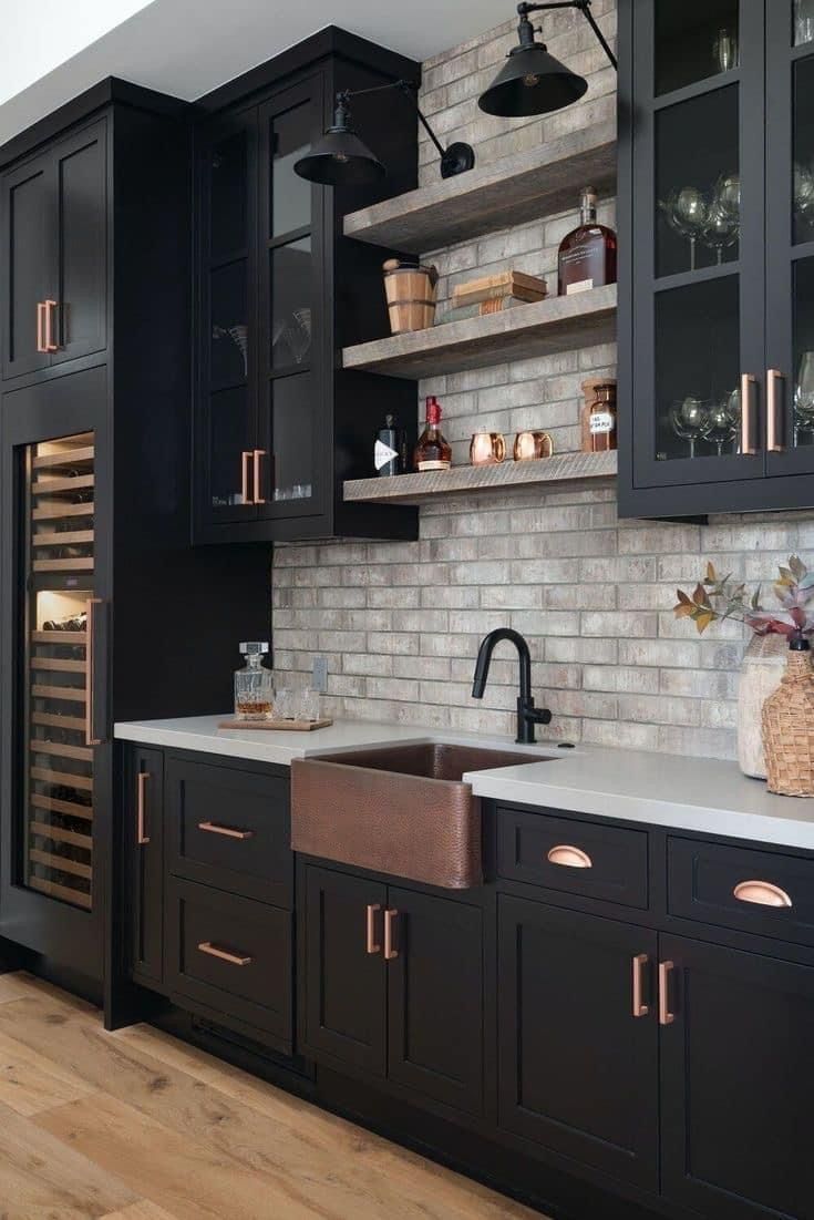 a kitchen with black cabinets and white counter tops, wooden flooring and open shelving