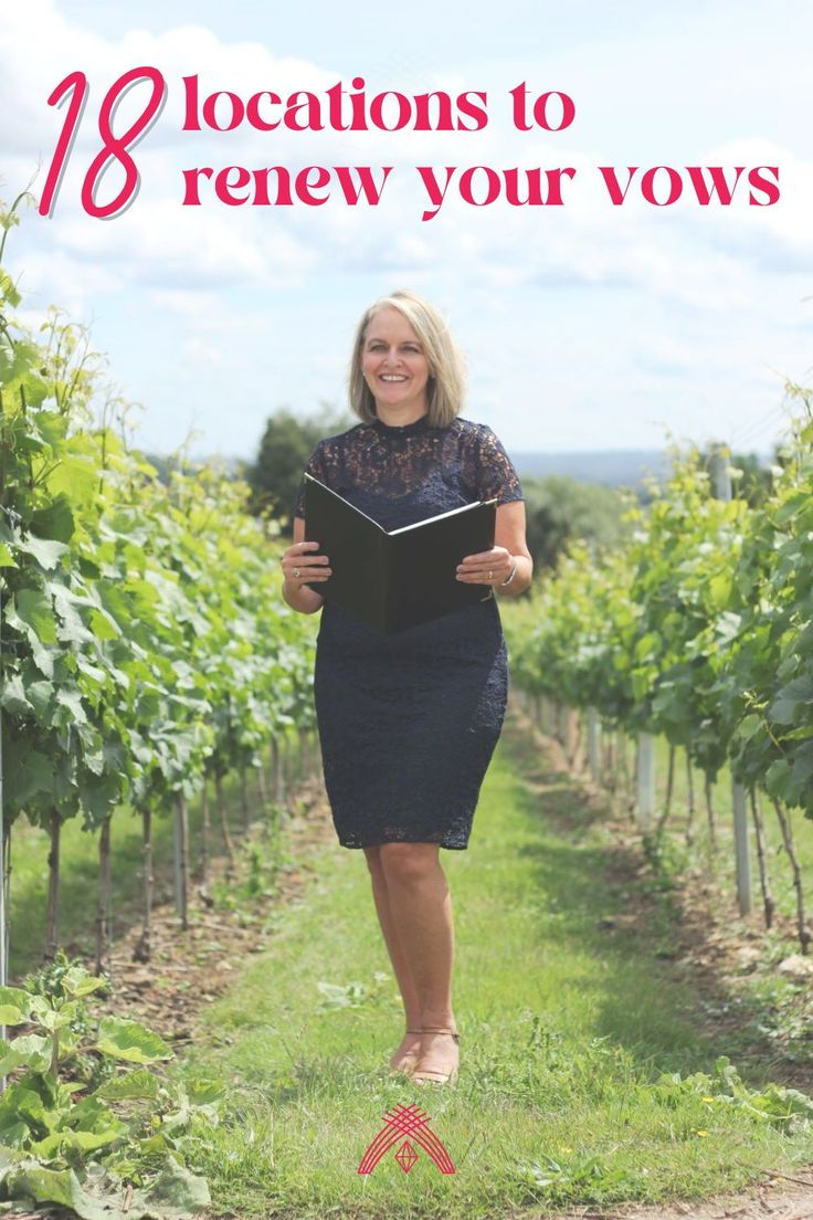 a woman standing in the middle of a vineyard holding an open book and looking at the camera