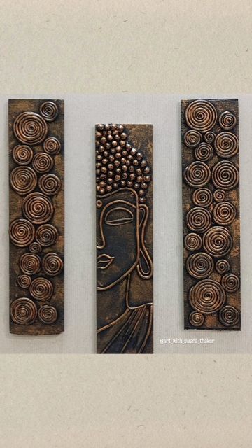 three metal wall hangings with designs on them