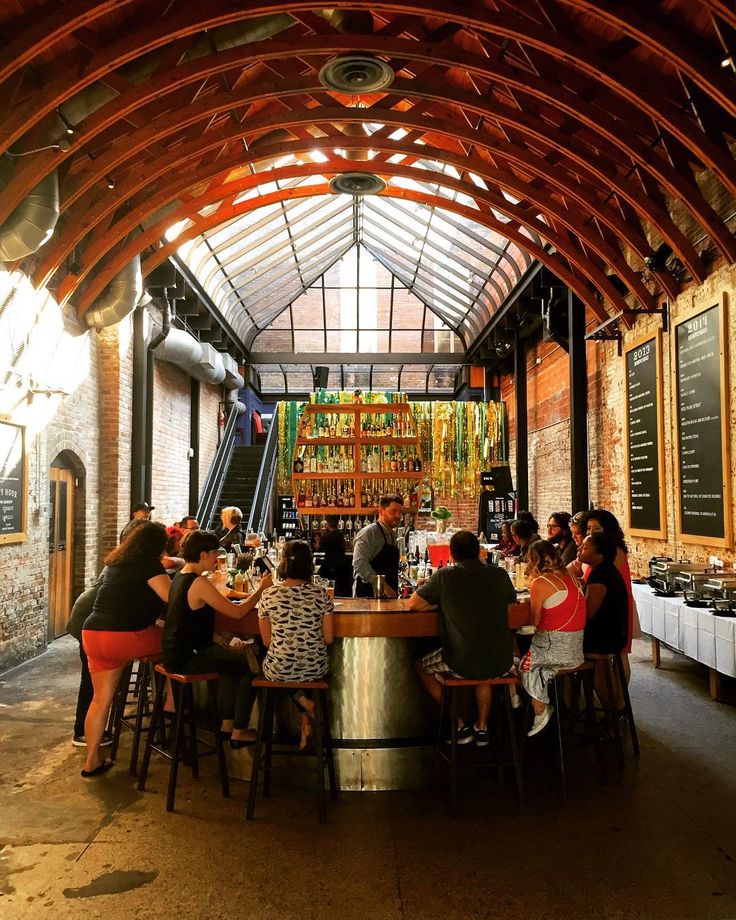 a group of people sitting around a table in a room filled with tables and chairs