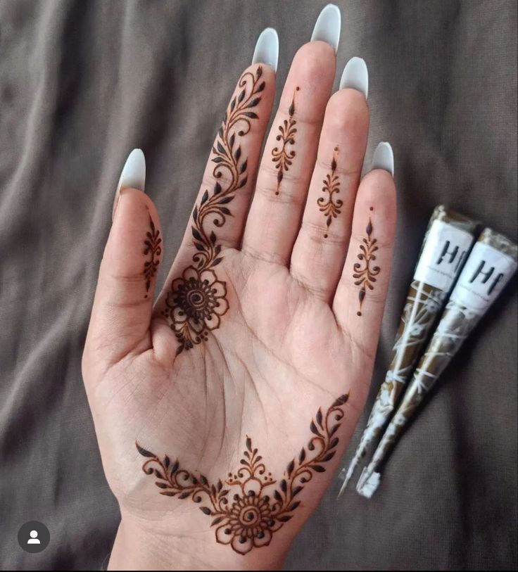 a woman's hand with henna tattoos on it