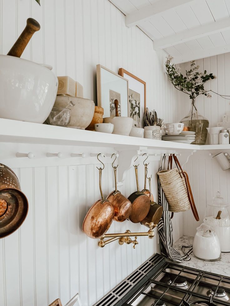 pots and pans are hanging on the shelves above the stove