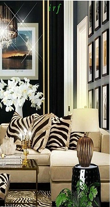 a living room with zebra print furniture and pictures on the wall behind it, along with a chandelier