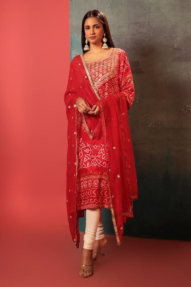 Red kurta with bandhani woven motifs and gota embroidered neckline. Paired with embroidered dupatta.
Components: 2
Pattern: Woven, Embroidery
Type Of Work: Bandhani, gota
Neckline: U neck
Sleeve Type: Three quarter
Fabric: Silk
Color: Red
Other Details: 
Cutwork border
Attached lining
Kurta Length: 47 inches
Note: Pant worn by the model is not for sale
Occasion: Sangeet - Aza Fashions Woven Embroidery, Kurta With Dupatta, Red Kurta, Embroidered Dupatta, Embroidered Neckline, Fabric Silk, U Neck, Red Silk, Cut Work