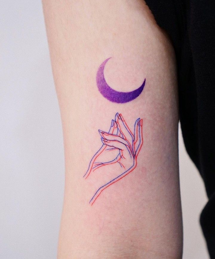 a woman's arm with a purple and blue tattoo design on the left side of her arm