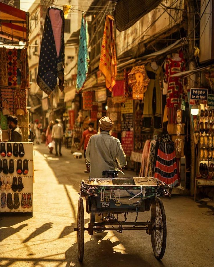 a man pushing a cart through an open market