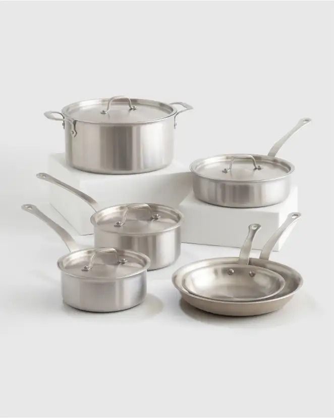 an assortment of pots and pans on a white surface with the lids down,