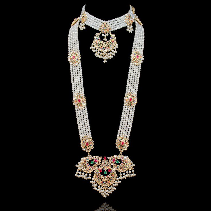 An exquisite set that draws attention with its echoes of traditional motifs. Alluringly timeless set enhanced with nauratan stones. Approximate mala length is 15". The set includes a choker paired with a mala, a matching maang teekah and a jhoomar and a pair of matching earrings. Approximate earrings length is 4.5". Gold-plated on high-quality brass as base metal. Made by order. Kindly allow 4-6 weeks for the delivery of this item. For custom or urgent requests, please contact support@alacouture Traditional Drape Wedding Jewelry With Latkans, Temple Jewelry Bridal Necklace With Tilla For Rituals, Ceremonial White Stone Work Necklace, White Kundan Necklace For Puja With Detailed Design, White Kundan Necklace With Intricate Design For Puja, Kundan Necklace With Stone Work For Navratri Rituals, Temple Jewelry Style Kundan Necklace For Rituals, Temple Jewelry Kundan Necklace For Rituals, Traditional Hand Set Bridal Necklace For Puja