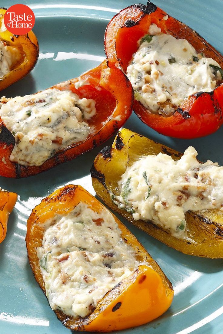 four stuffed peppers on a blue plate with white sauce