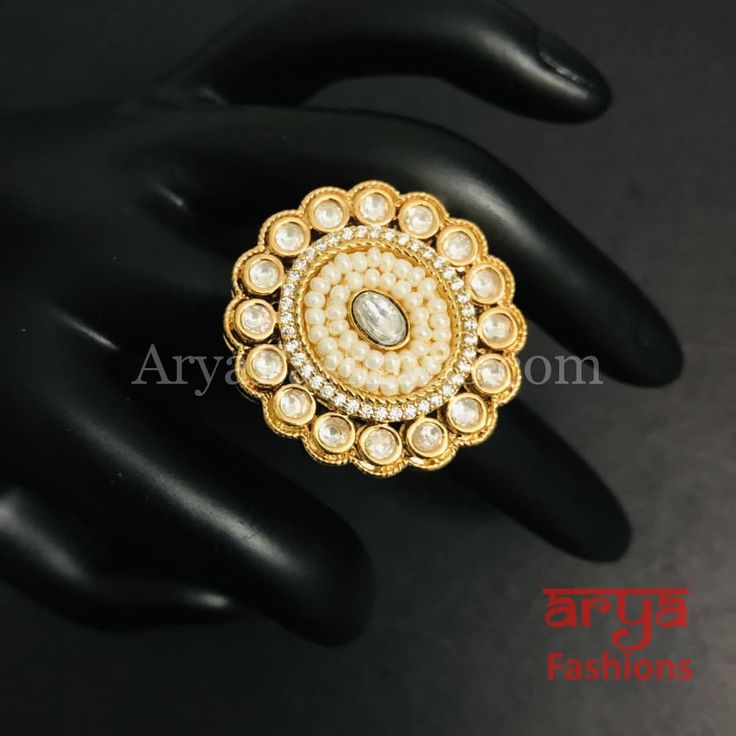 Esha Pearl Kundan Jadau CZ Round Ring Features: Adjustable Kundan Ring to match any finger size 22 Karat Gold Finish Lightweight Jewelry Made in Brass with very high quality Pacchi Kundan and CZ. Suitable for any occasion and traditional or Modern attire Ready to ship and available for local pickup from 23059. Please message us for more details Free shipping on orders above $75 within USA. Toe Rings For Anniversary And Festivals, White Stone Work Wedding Gift, Handmade Temple Jewelry Rings For Wedding, Traditional Rings For Festival Celebrations, Traditional Toe Rings For Weddings, Traditional Festive Jewelry Ring, Elegant Rings For Festive Celebrations, Traditional Wedding Toe Rings, Elegant Festive Rings For Celebration