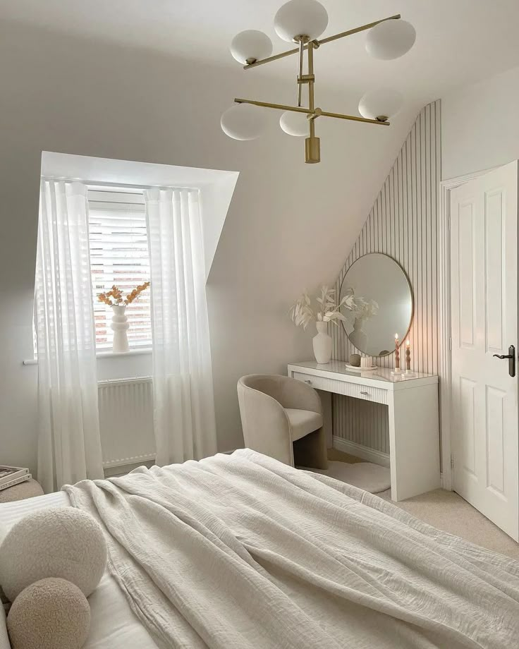 a bedroom with a bed, desk and mirror in the corner next to a window