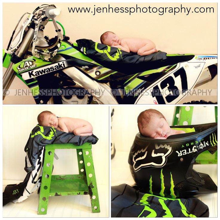 a baby laying on top of a motorbike with green and black paint scheme