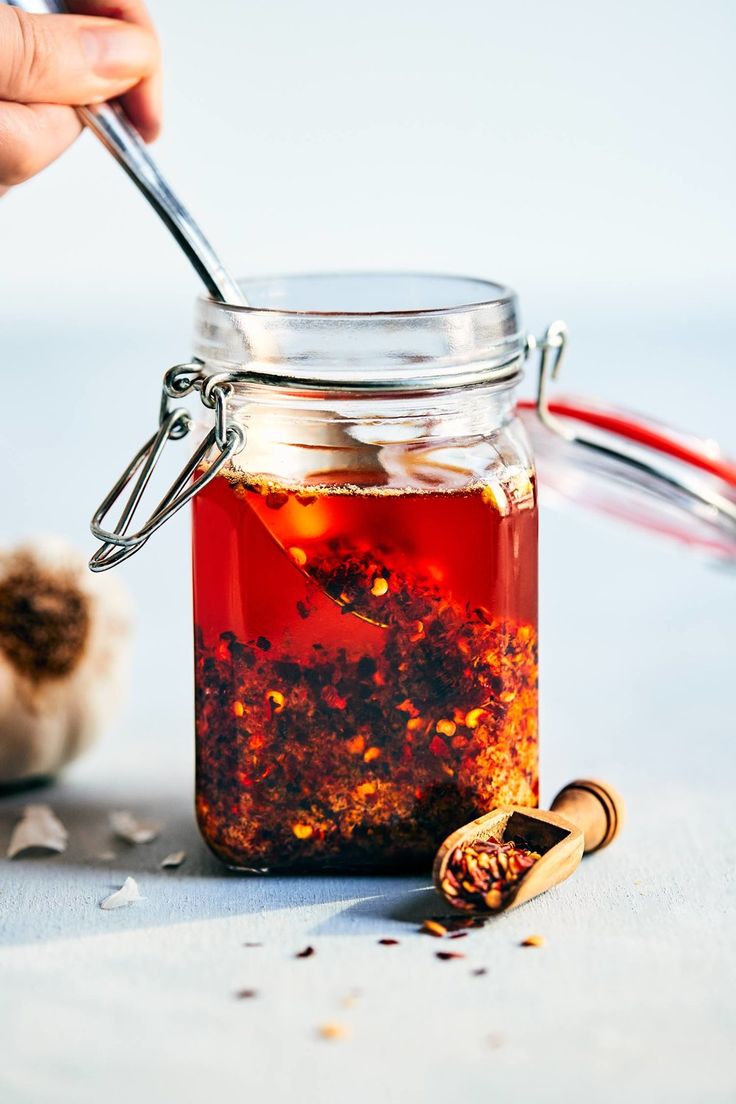 a jar filled with red liquid and spices