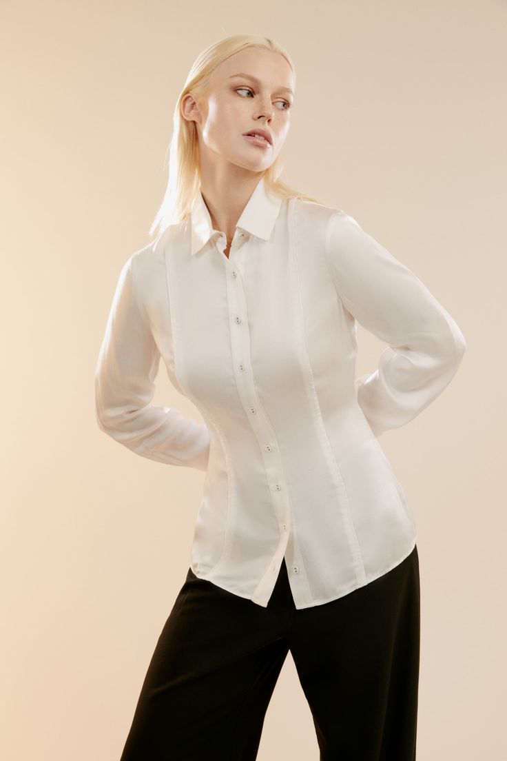 Effortlessly elegant. A decadent satin fabrication and minimalist silhouette with piping details at the front creates an understated yet impactful design. Layer with a blazer and tailored pants for the office, or wear with a skirt for weekend engagements.

SIZING: Slim fit. AU: Model wears a size 8 / US: Model wears a size 4.

FABRICATION: 100% Viscose.

- Piping detail at front
- Functional buttons on front and cuffs
- Collarded neckline Elegant Blouse With Lapel Collar For Business Casual, Sleek Silk Blouse For Work, Sleek Silk Workwear Blouse, Tailored Elegant Blouse For Business Casual, Elegant Tailored Blouse For Business Casual, Fitted Solid Color Elegant Blouse, Elegant Formal Blouse With Concealed Placket, Elegant Fitted Blouse, Elegant Silk Blouse For Office