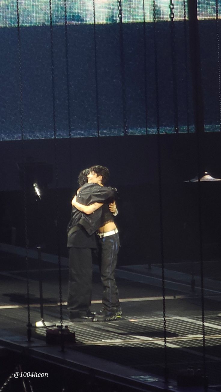 two people embracing each other on stage