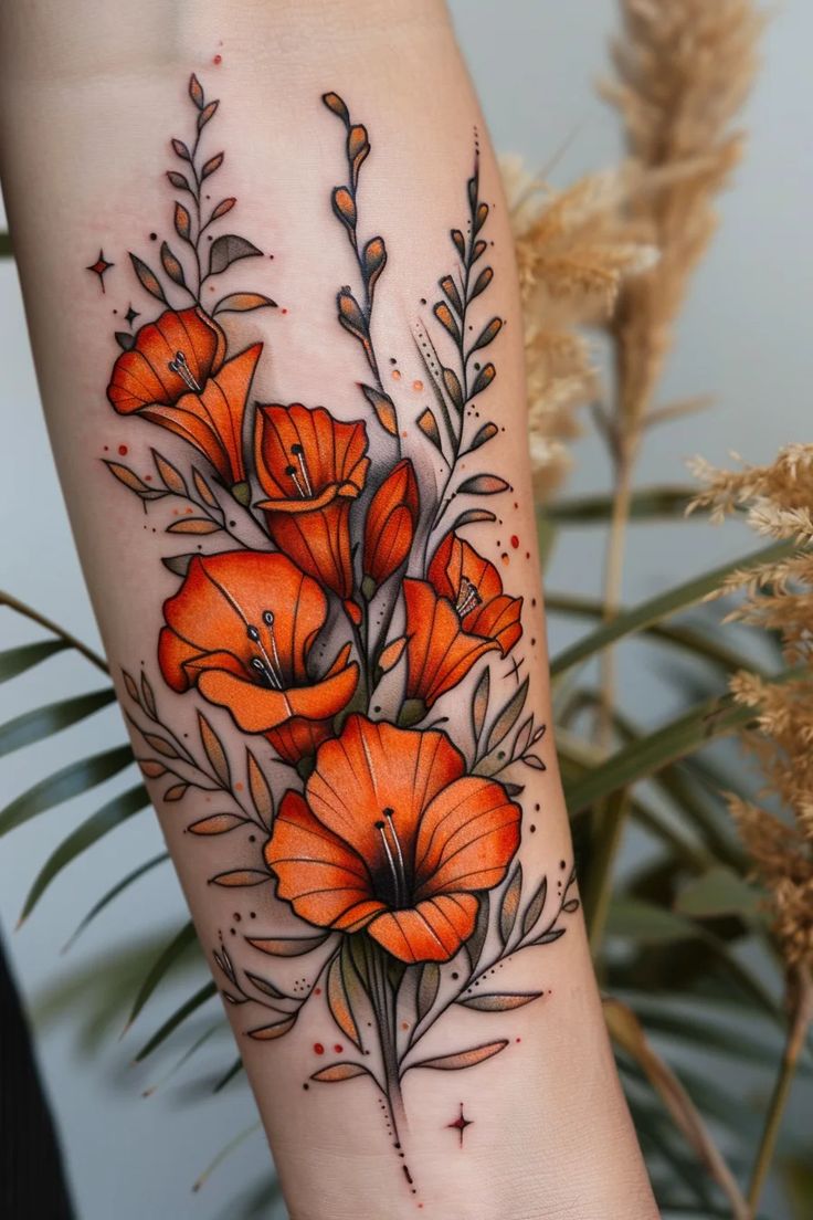 an orange flower tattoo on the arm