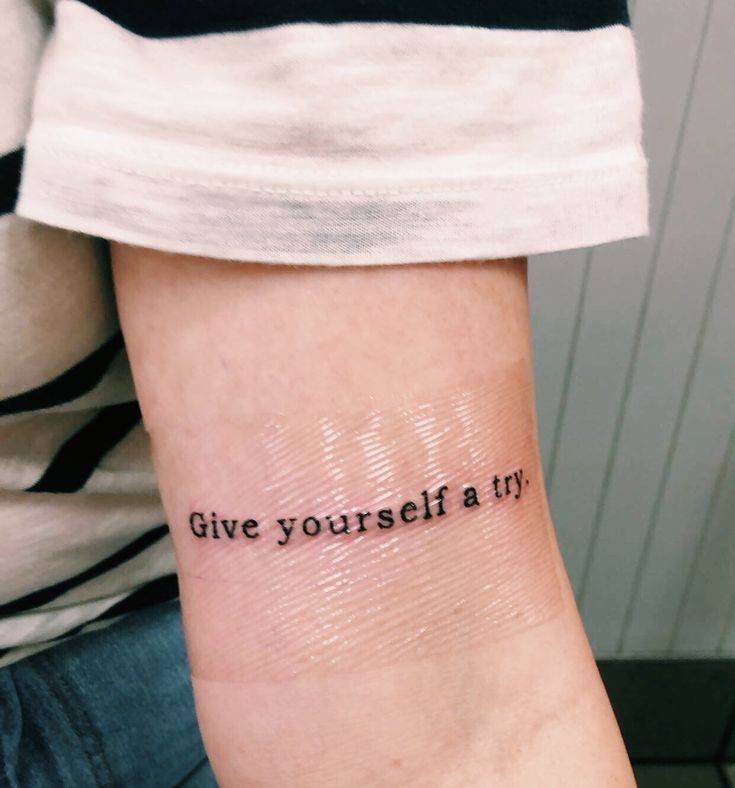 a person with a tattoo on their arm that reads give yourself a try, and the words are written in cursive font