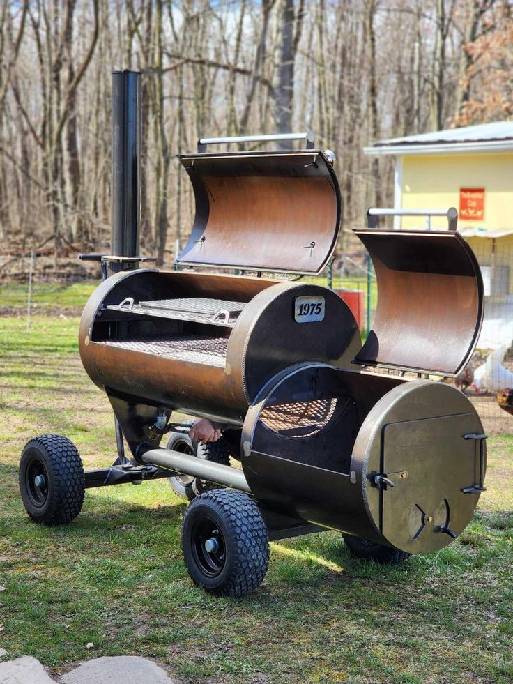 an outdoor bbq grill on wheels in the grass