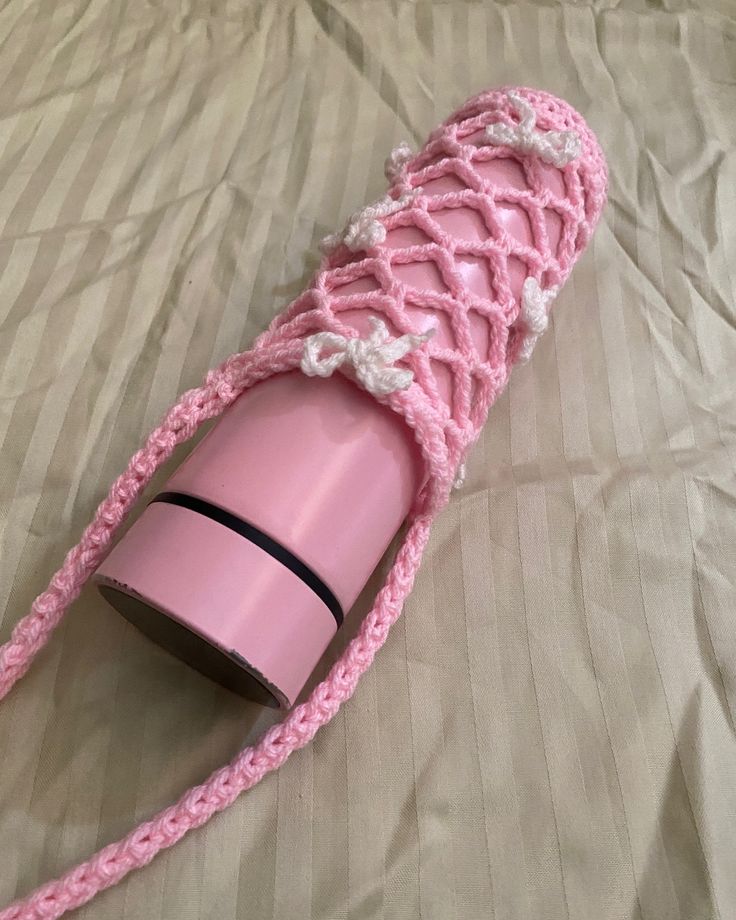 a pink hair dryer laying on top of a bed