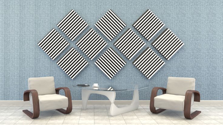 two chairs and a table in front of a wall with black and white squares on it