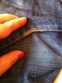 someone is holding their hand on the pocket of a pair of jeans