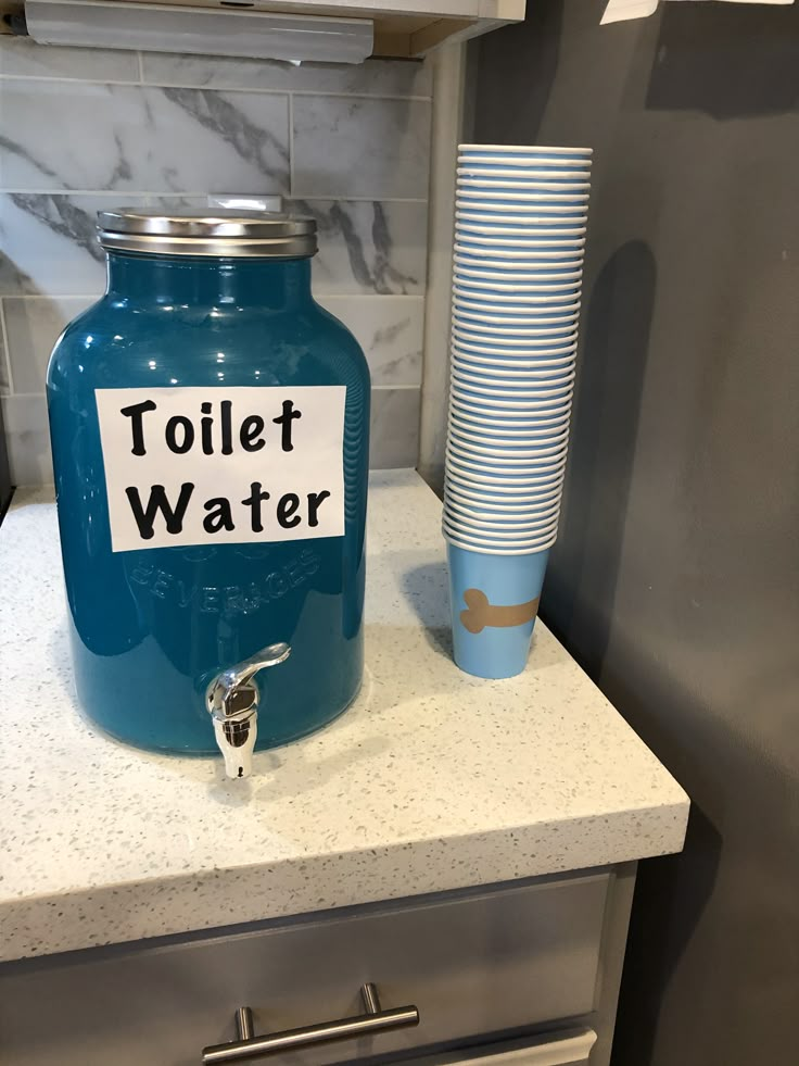 a blue canister sitting on top of a counter next to a cup and paper plate