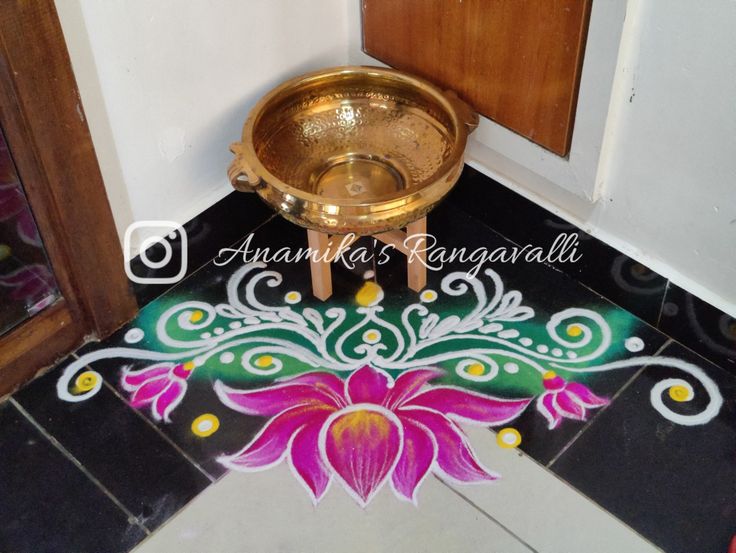 a gold bowl sitting on top of a black and white tiled floor next to a wooden door