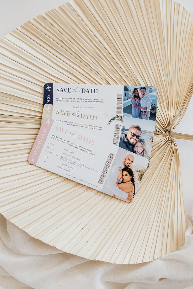 a fan with two photos attached to it on top of a white table cloth next to an umbrella