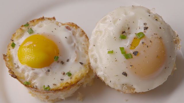 two fried eggs are on a white plate with green sprinkles around them