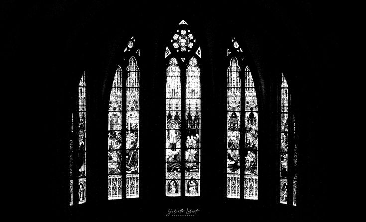 a black and white photo of three stained glass windows