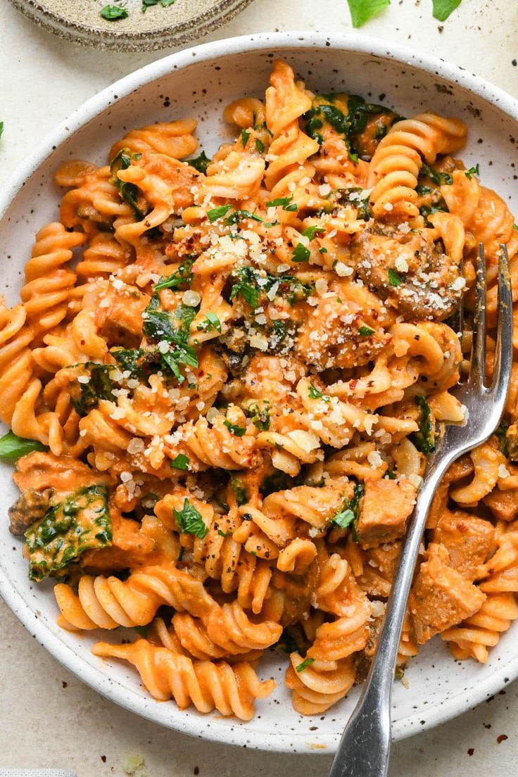 a white bowl filled with pasta and sauce