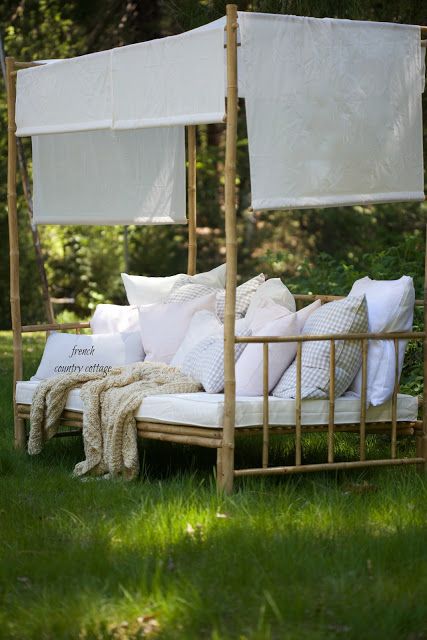 a canopy bed with pillows on it in the grass