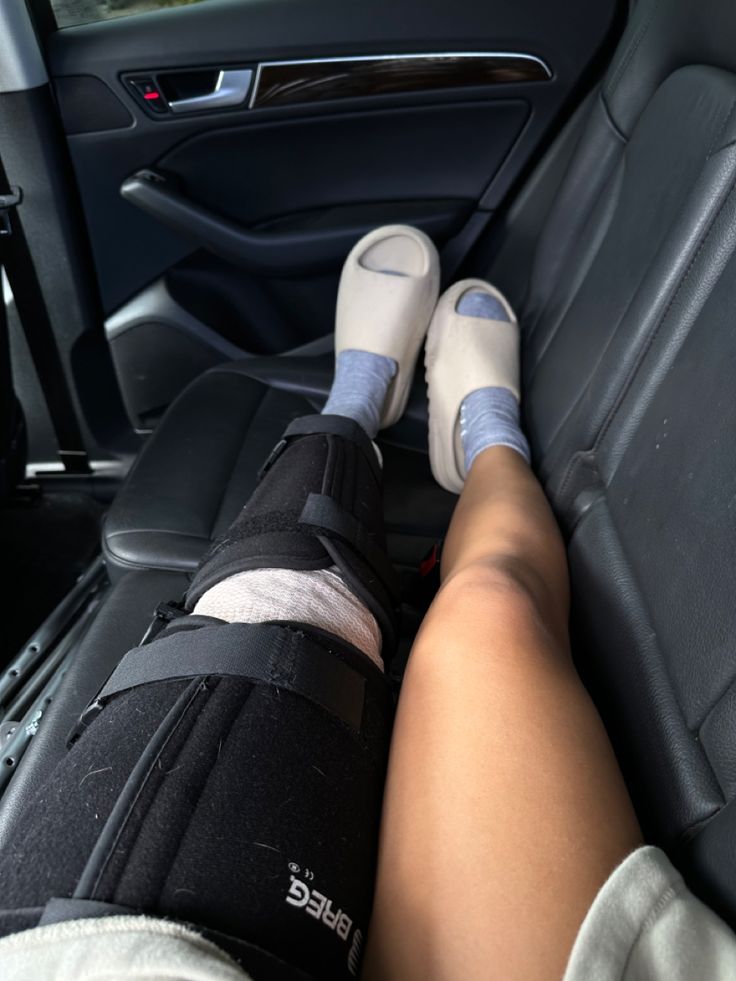 a person sitting in the back seat of a car with their feet propped up on an arm rest