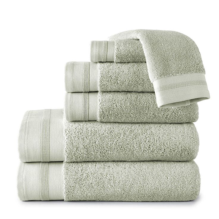 a stack of white towels stacked on top of each other in front of a white background