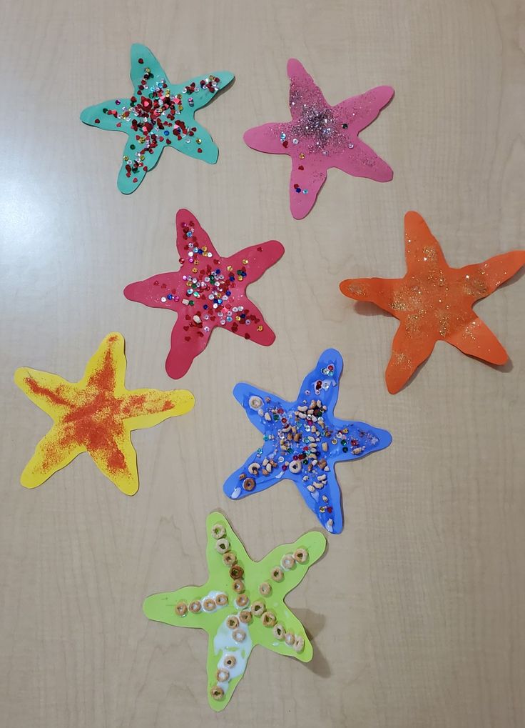 five different colored stars on a white surface