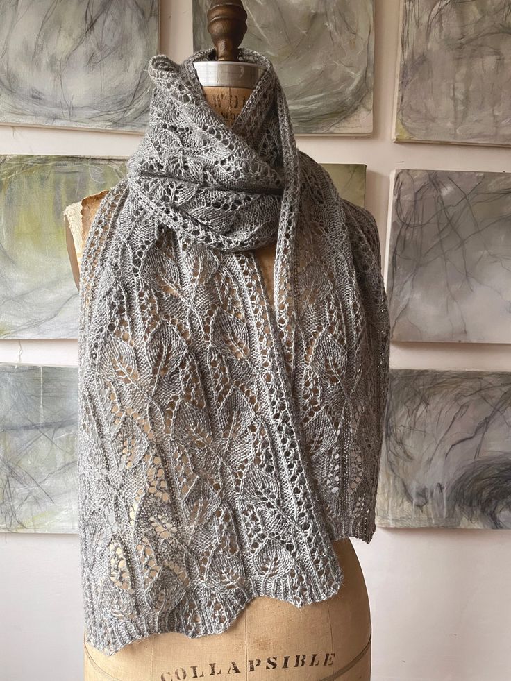 a knitted shawl sits on a mannequin