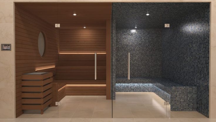 a bathroom with a glass door and tiled wall next to a walk - in shower